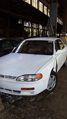 A white car is parked in front of a building.