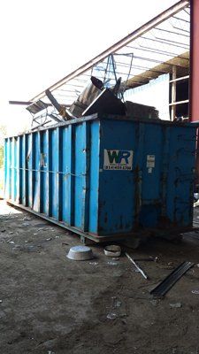 A large blue dumpster with wr written on it