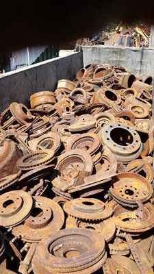 A pile of rusty brake rotors is sitting on top of each other.