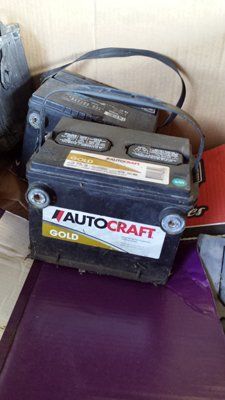 Two batteries are sitting on top of each other on a table.
