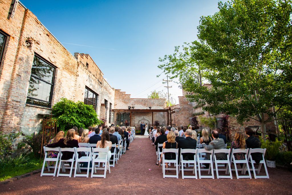 A group of people sitting in white chairs in front of a building