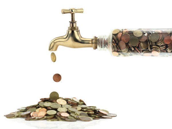 A tap leaking coins into a growing pile, symbolizing financial leakage or wealth accumulation.