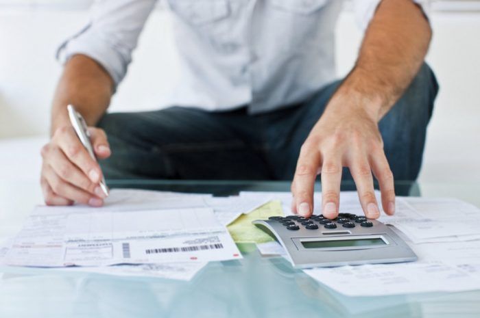 man with calculator budgeting