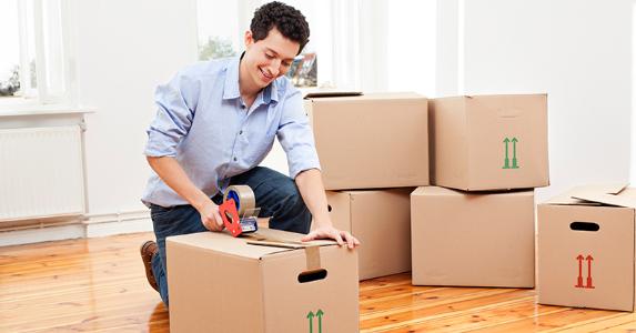 man taping moving box