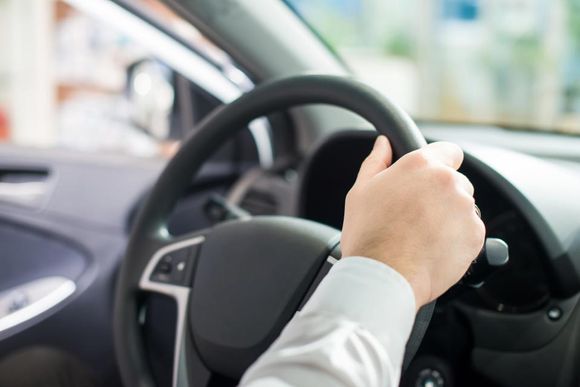 individual holding the steering wheel