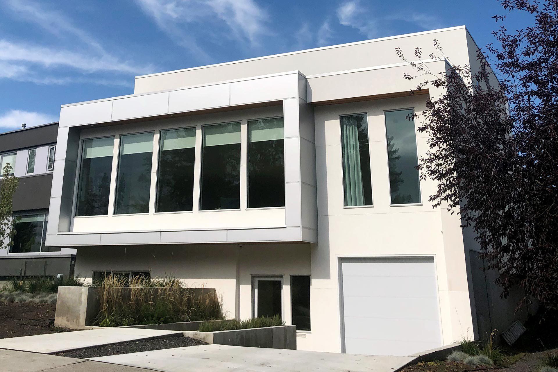 A large white house with lots of windows and a garage