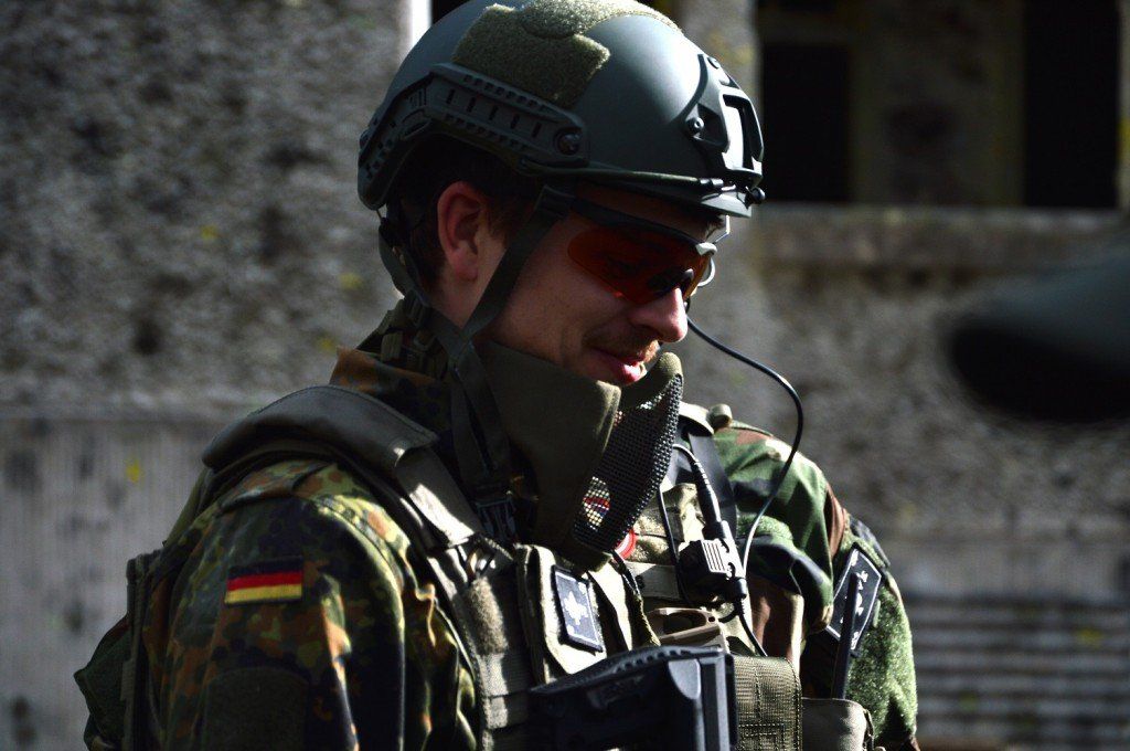 Ein Mann in Militäruniform trägt einen Helm und eine Sonnenbrille.