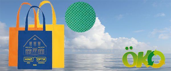 Eine blaue Tasche mit einem Haus darauf ist neben einer gelben Tasche