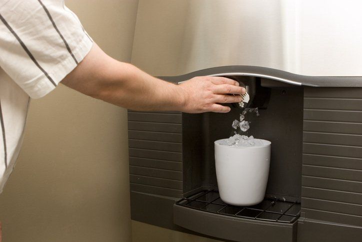 a man is pouring ice into a white cup