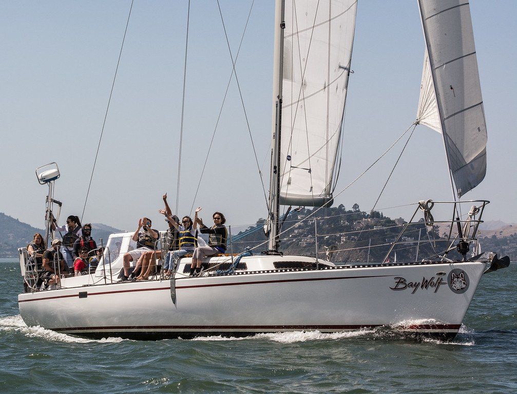A group enjoying a sunny day of sailing on Bay Wolf on San Francisco Bay.