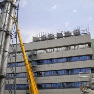 autogru davanti a un edificio per installazione insegna