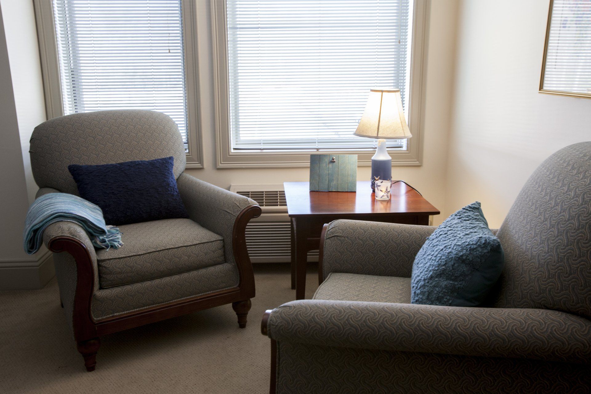 Two large, comfortable chairs in the corner with a table in between them in the Filedstone Suites.