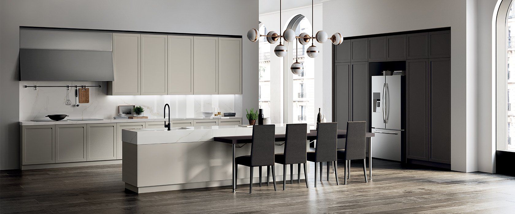 Cucina moderna con mobili beige e grigi, isola, tavolo da pranzo e lampadario.