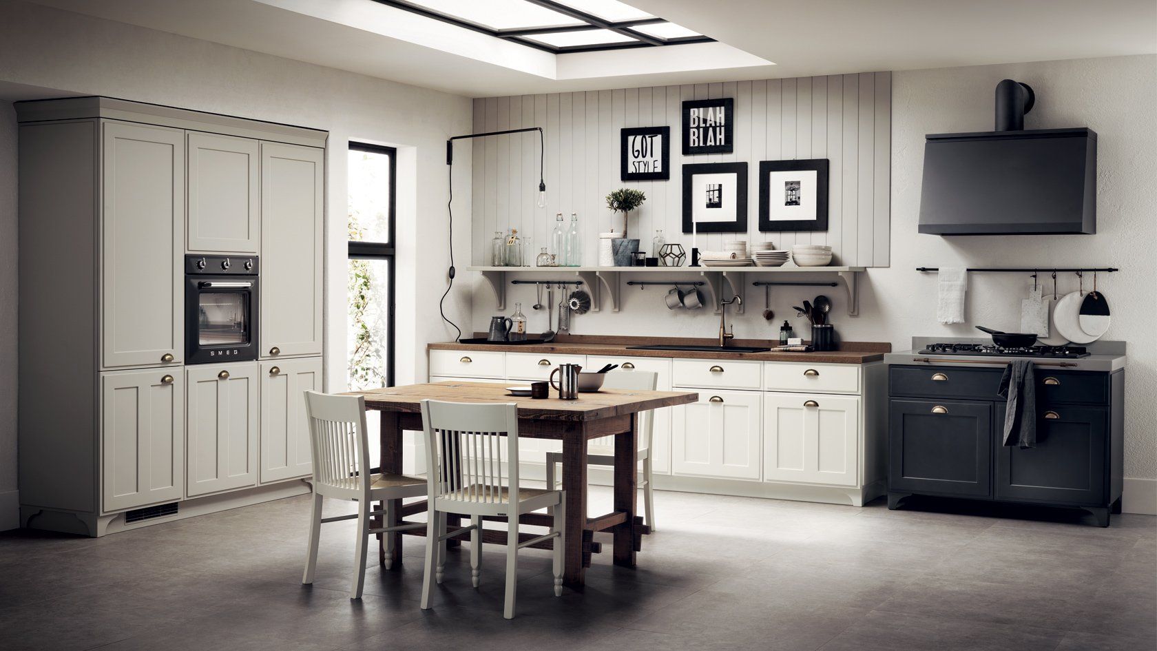 Cucina rustica con tavolo in legno, mobili bianchi ed elettrodomestici scuri.
