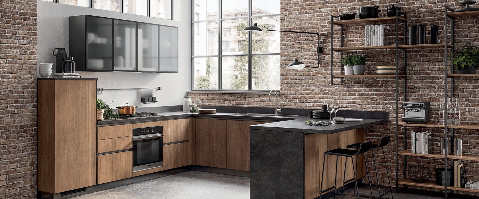 Cucina industriale con parete in mattoni, mobili in legno e scaffalature in metallo.
