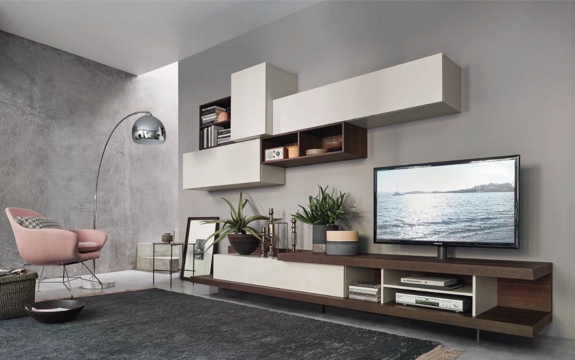 Soggiorno moderno con mensole sospese, TV, sedia e piante. Legno chiaro e scuro, pareti grigie e un tappeto.