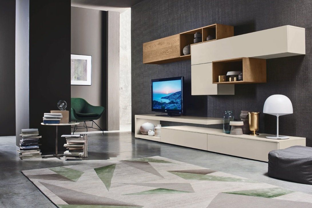 Soggiorno moderno con pensili beige e in legno, TV, tappeto geometrico e pareti grigio scuro.