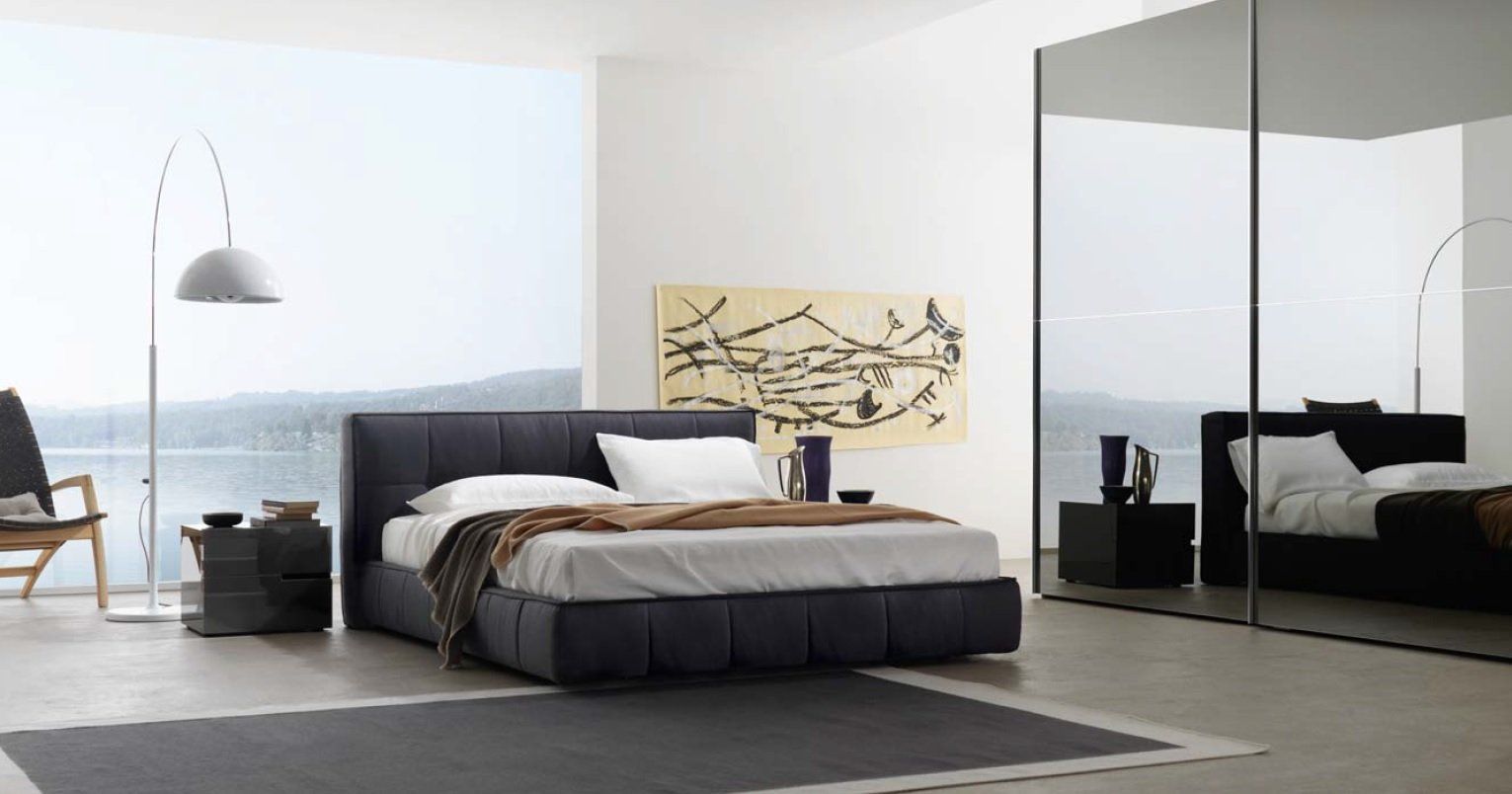 Camera da letto moderna con letto, opere d'arte e armadio a specchio.
