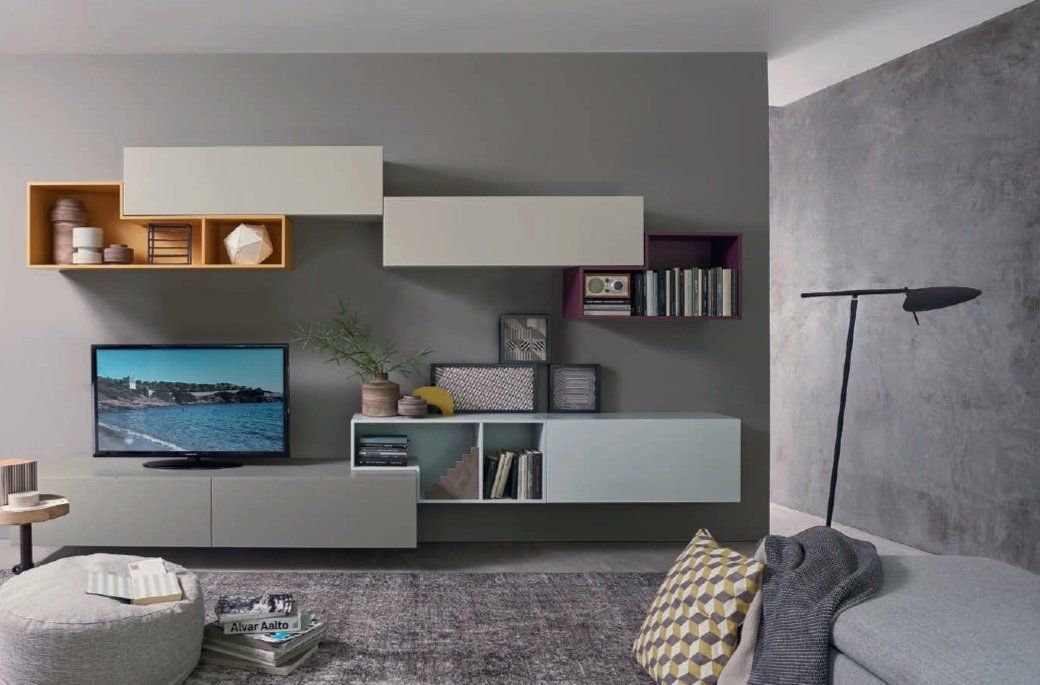 Soggiorno moderno con mensole sospese e TV contro una parete grigia.