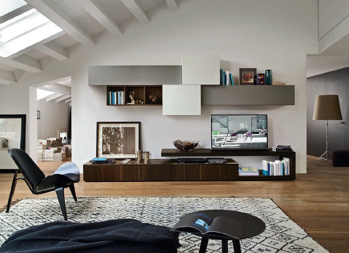 Soggiorno moderno con TV, mobili in legno scuro e mensole sospese; tonalità di grigio, bianco e marrone.