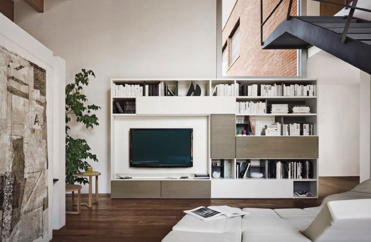 Soggiorno moderno con scaffali bianchi e marroni integrati, TV, libri e un divano componibile.
