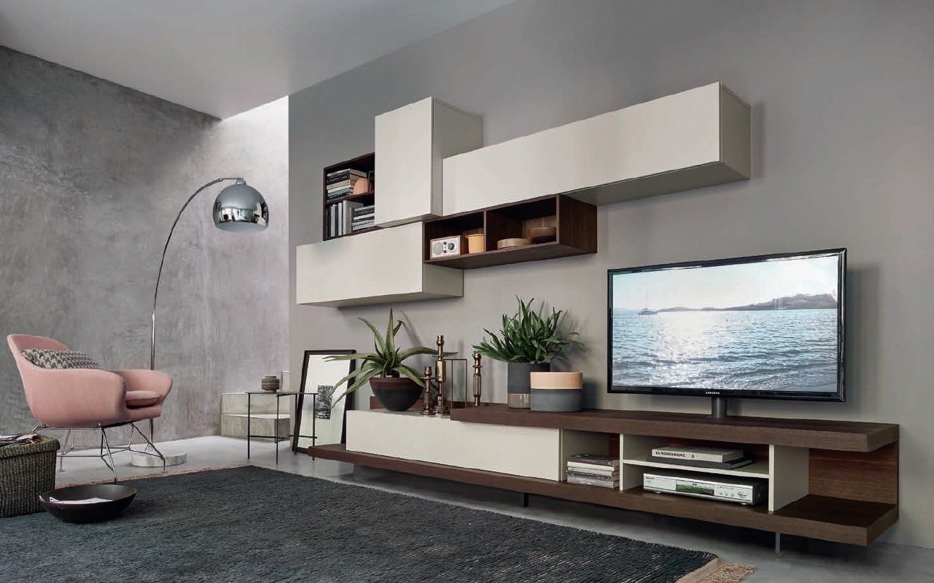 Soggiorno moderno con mensole sospese, TV, pareti grigie e una poltrona rosa.