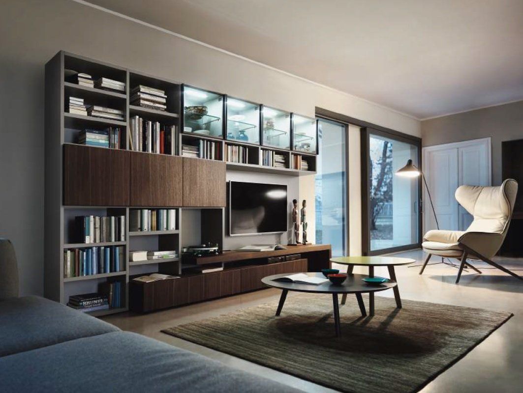 Soggiorno moderno con libreria integrata, TV, divano, sedia, tavolino e porta scorrevole in vetro.