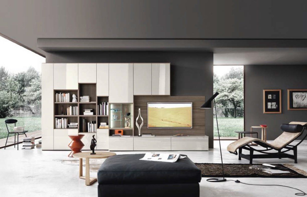 Soggiorno moderno con spazio di archiviazione incorporato, TV, divano e poltrona; colori neutri e vista sull'esterno.