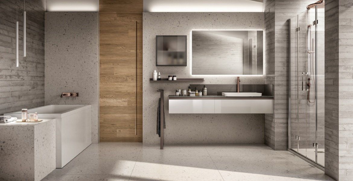 Bagno moderno con pareti in cemento, porta in legno e mobile lavabo bianco sospeso.