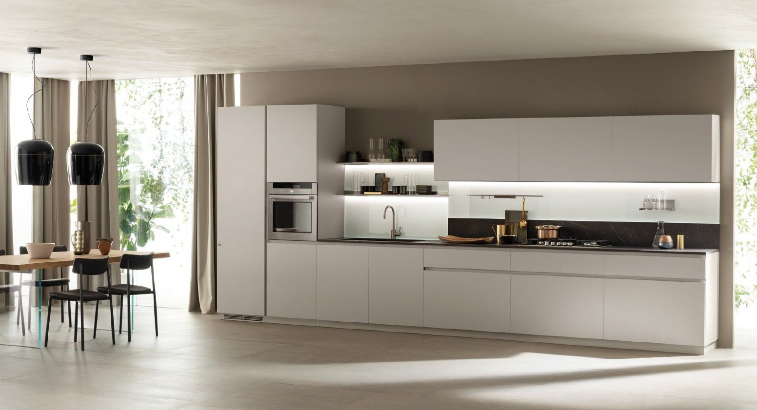 Moderna cucina bianca con mobili eleganti, elettrodomestici da incasso e tavolo da pranzo.