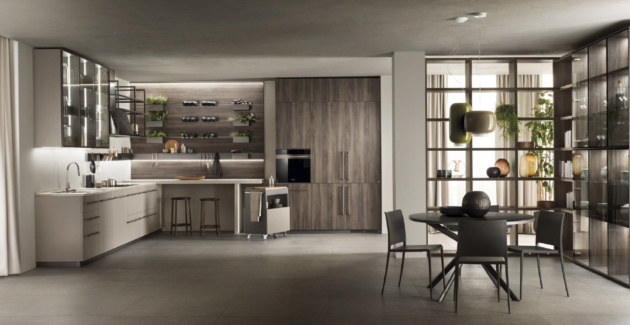 Cucina moderna con zona pranzo, caratterizzata da elementi grigi, in legno e in vetro.