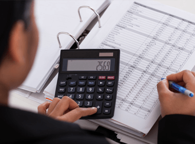 Young Businesswoman Doing Calculations In The Office