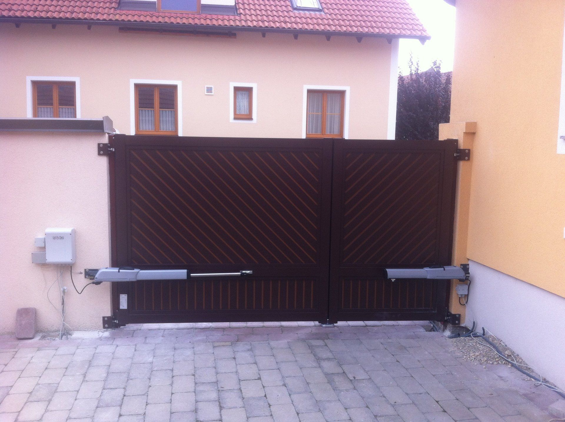 Vor einem Haus steht ein braunes Tor offen