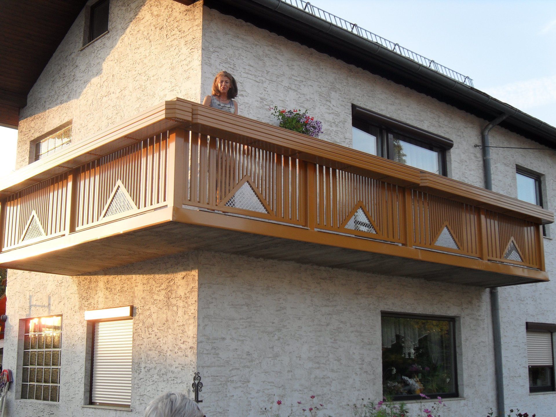 Eine Frau steht auf einem Balkon eines Hauses