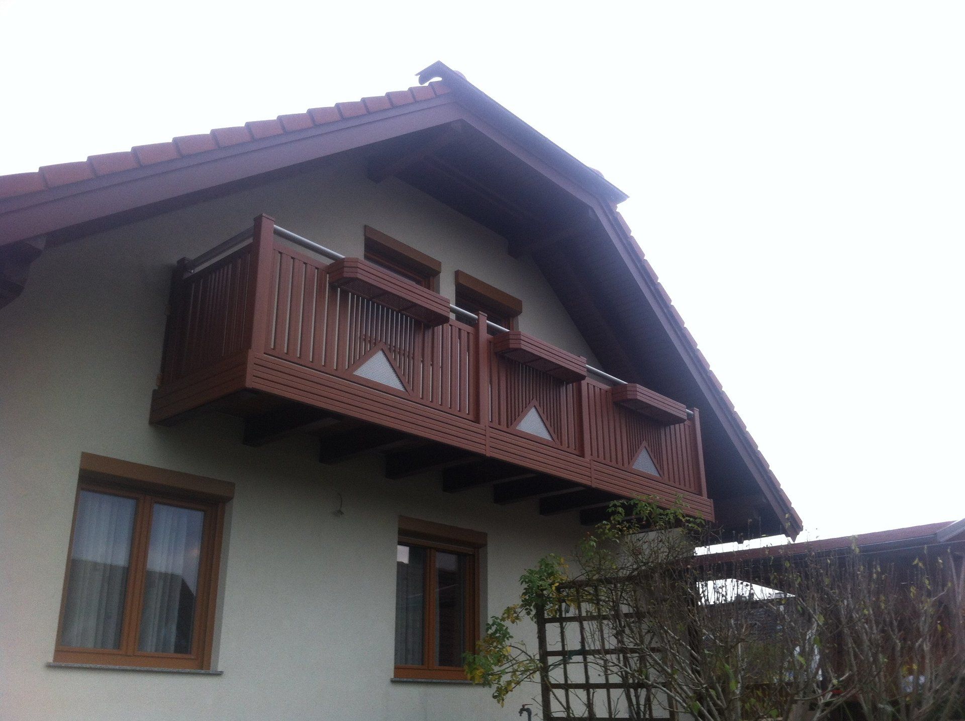 Ein Haus mit einem Balkon auf dem Dach