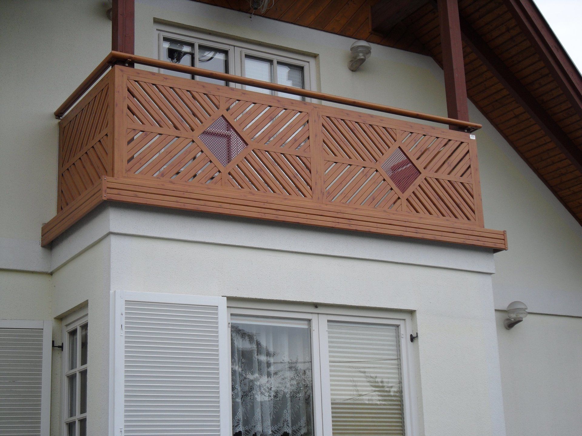 Ein Balkon an der Seite eines Hauses mit einem Holzgeländer