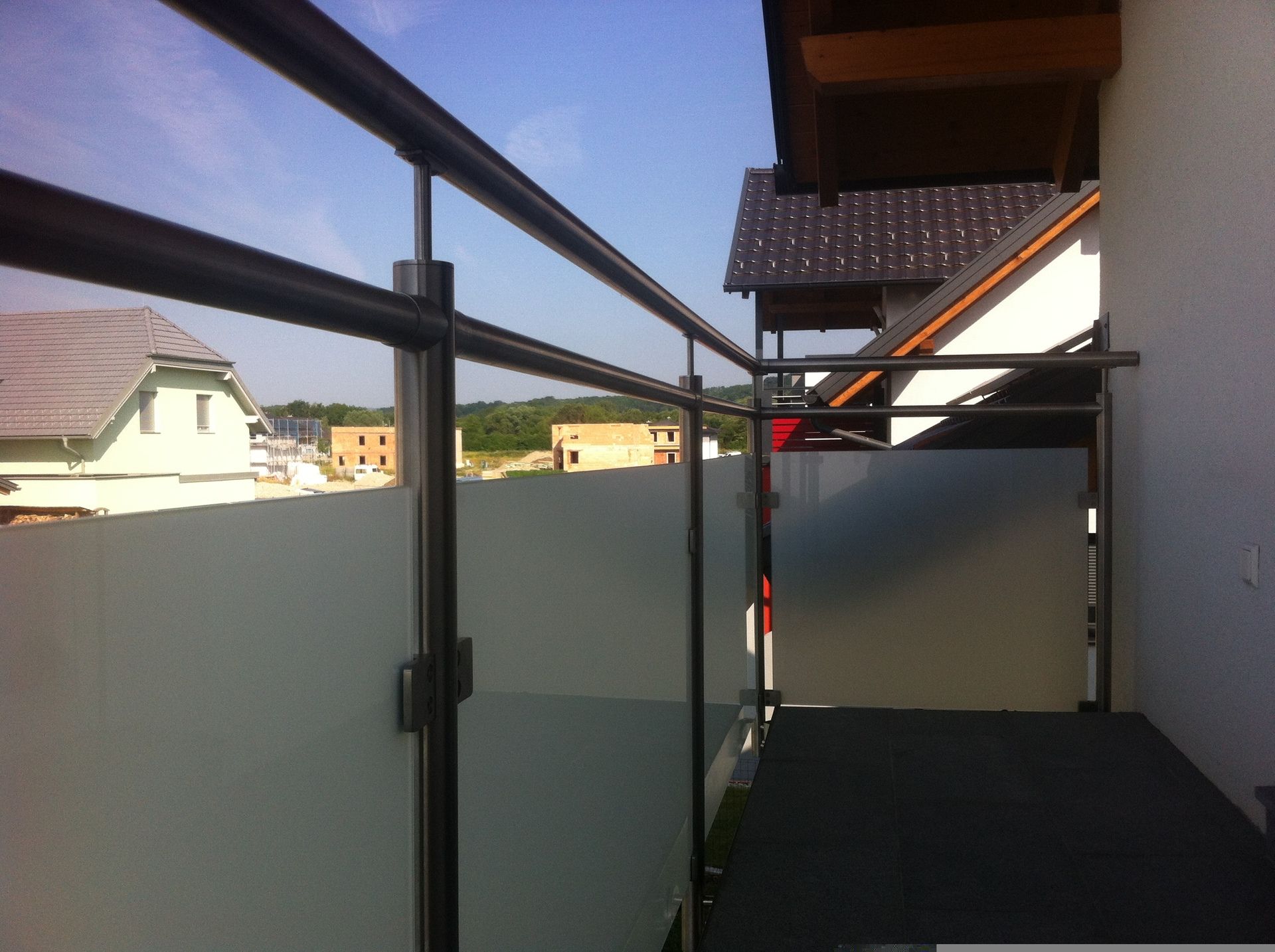 Ein Balkon mit Edelstahlgeländer und Milchglas