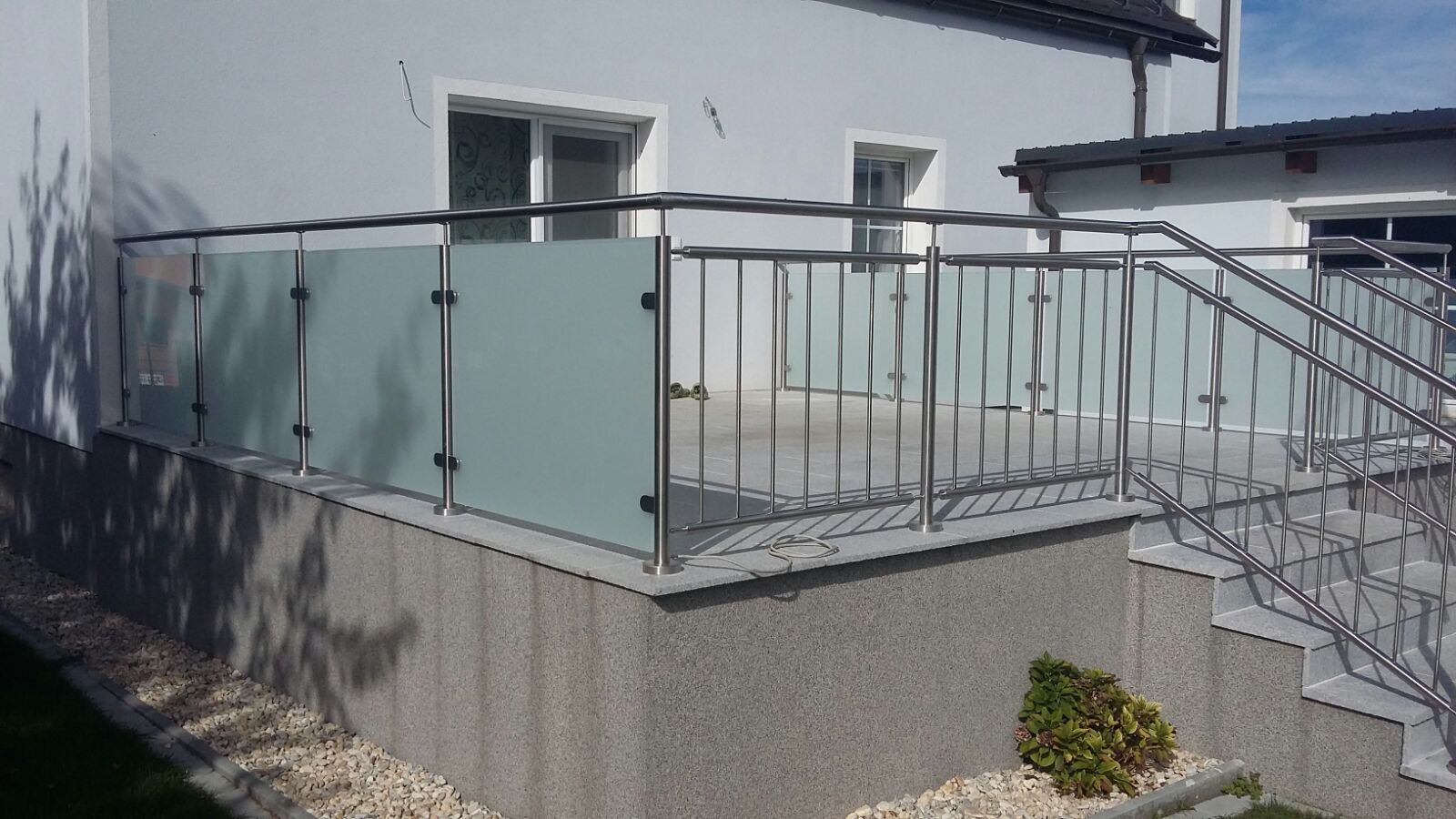 Ein Balkon mit Edelstahlgeländer und Milchglas.