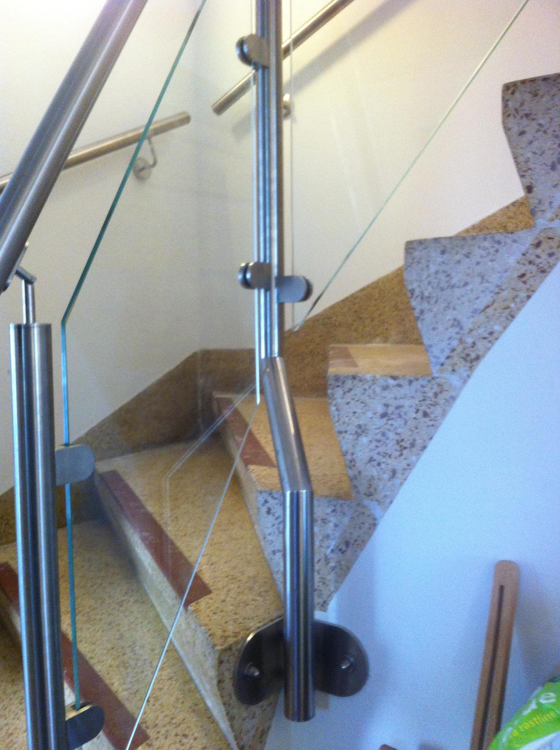Eine Treppe mit einem Metallgeländer und einem Glasgeländer
