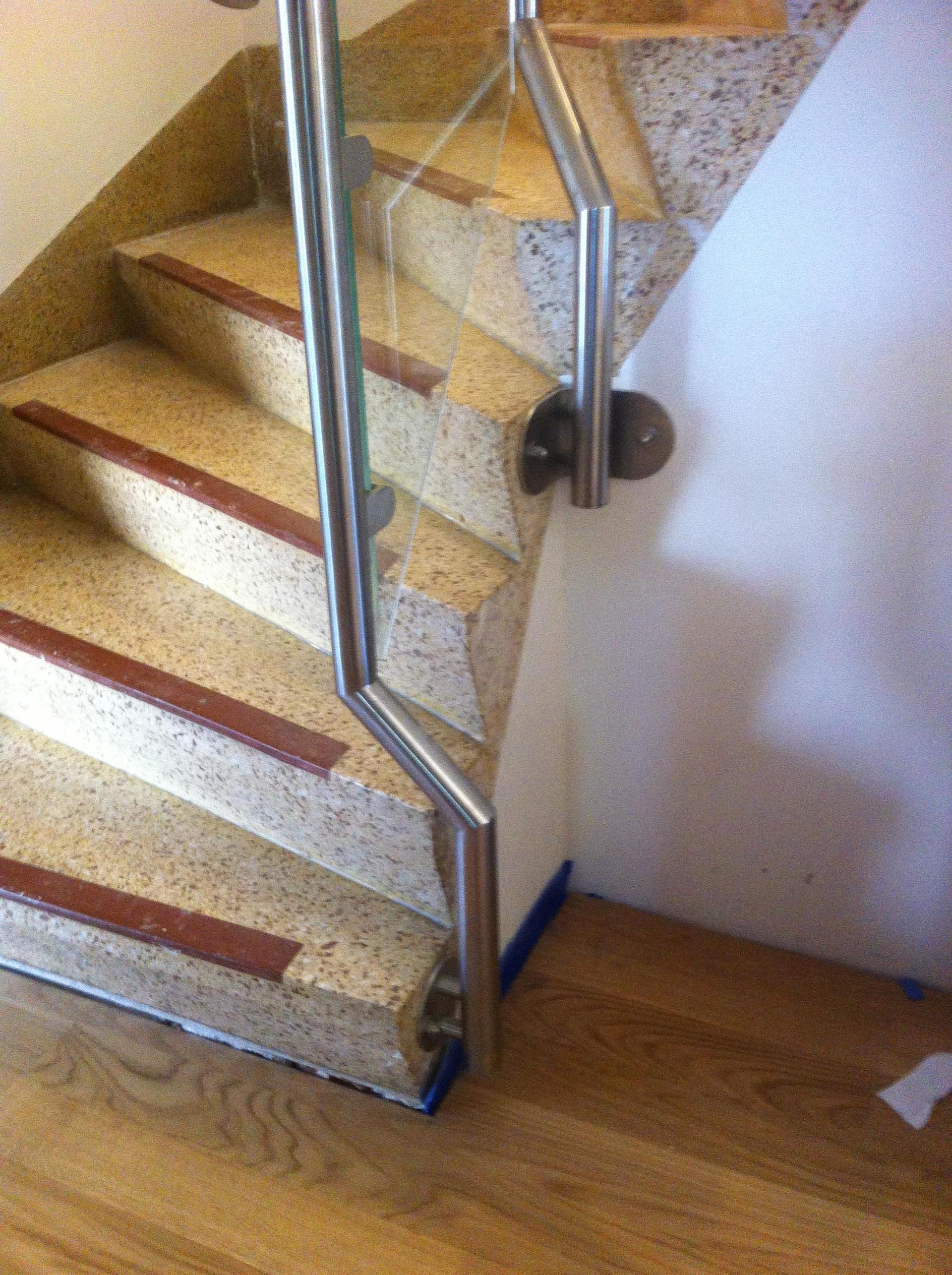 Eine Nahaufnahme einer Treppe mit einem Glasgeländer.