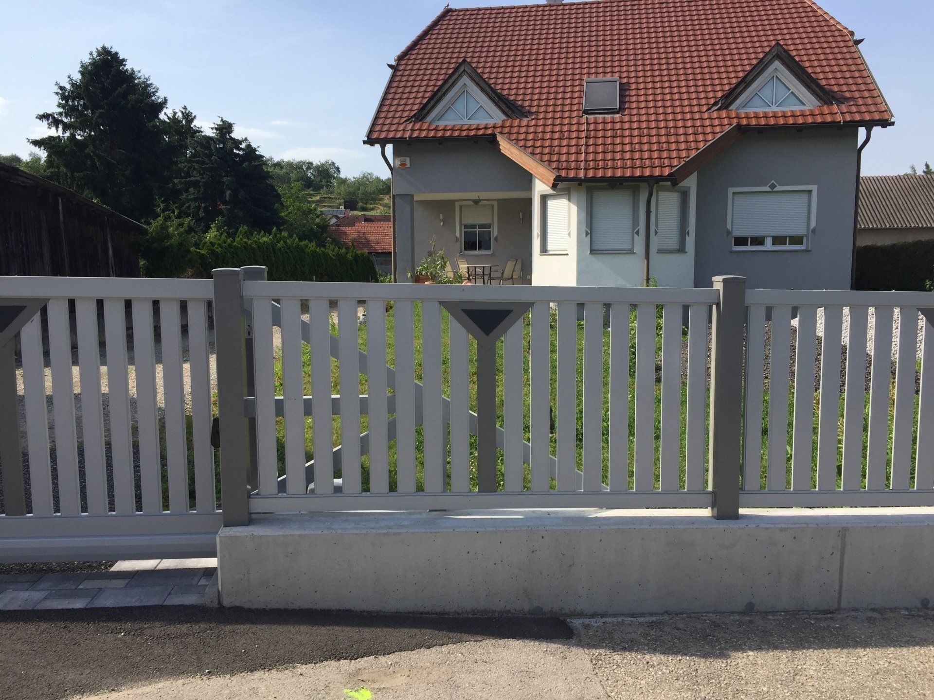 Ein Haus mit einem weißen Zaun davor