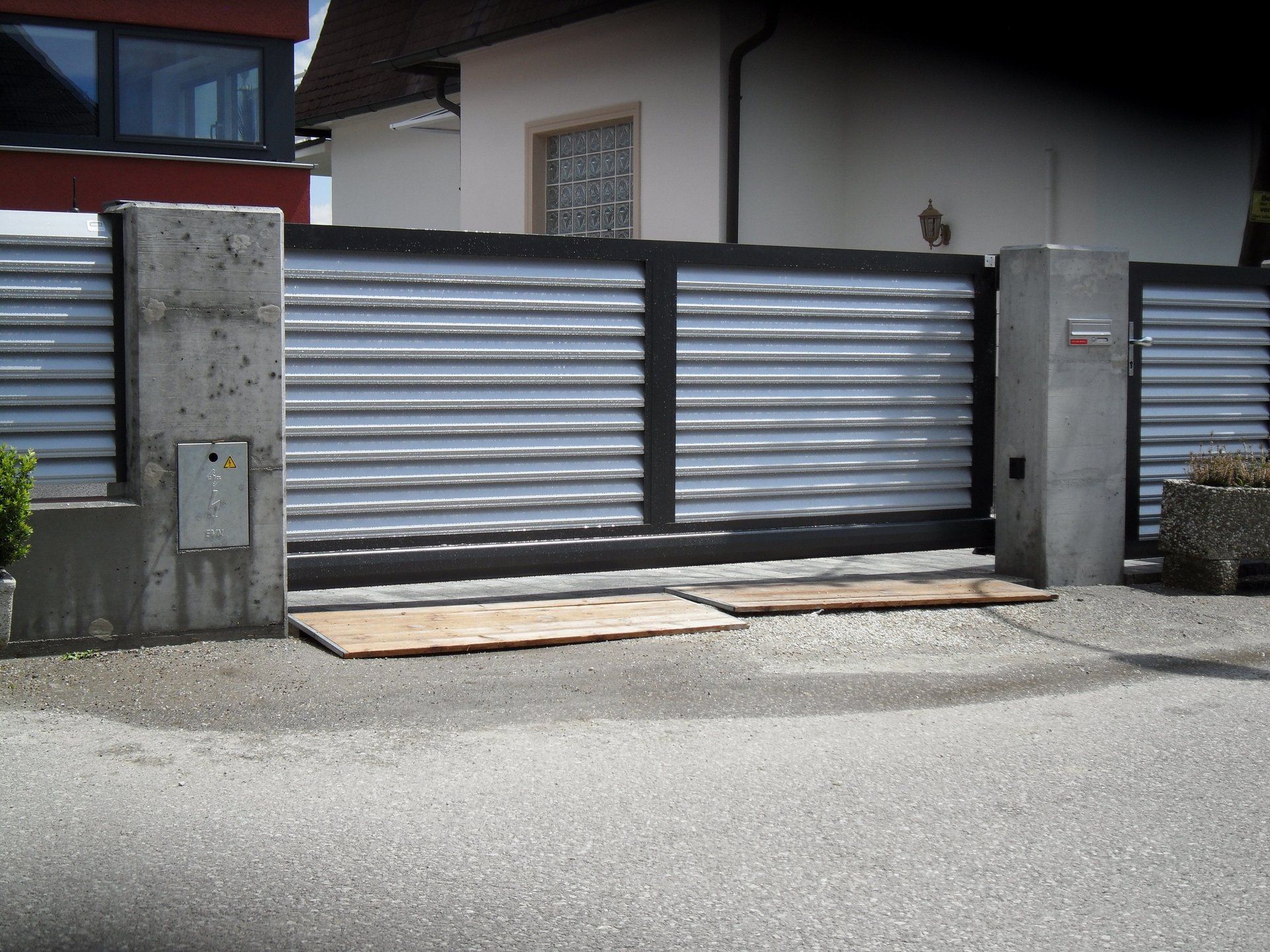 Ein Zaun mit Schiebetor vor einem Haus