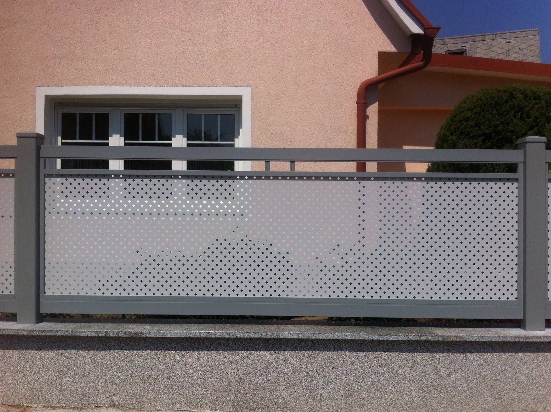 Ein Haus mit einem grauen Zaun davor