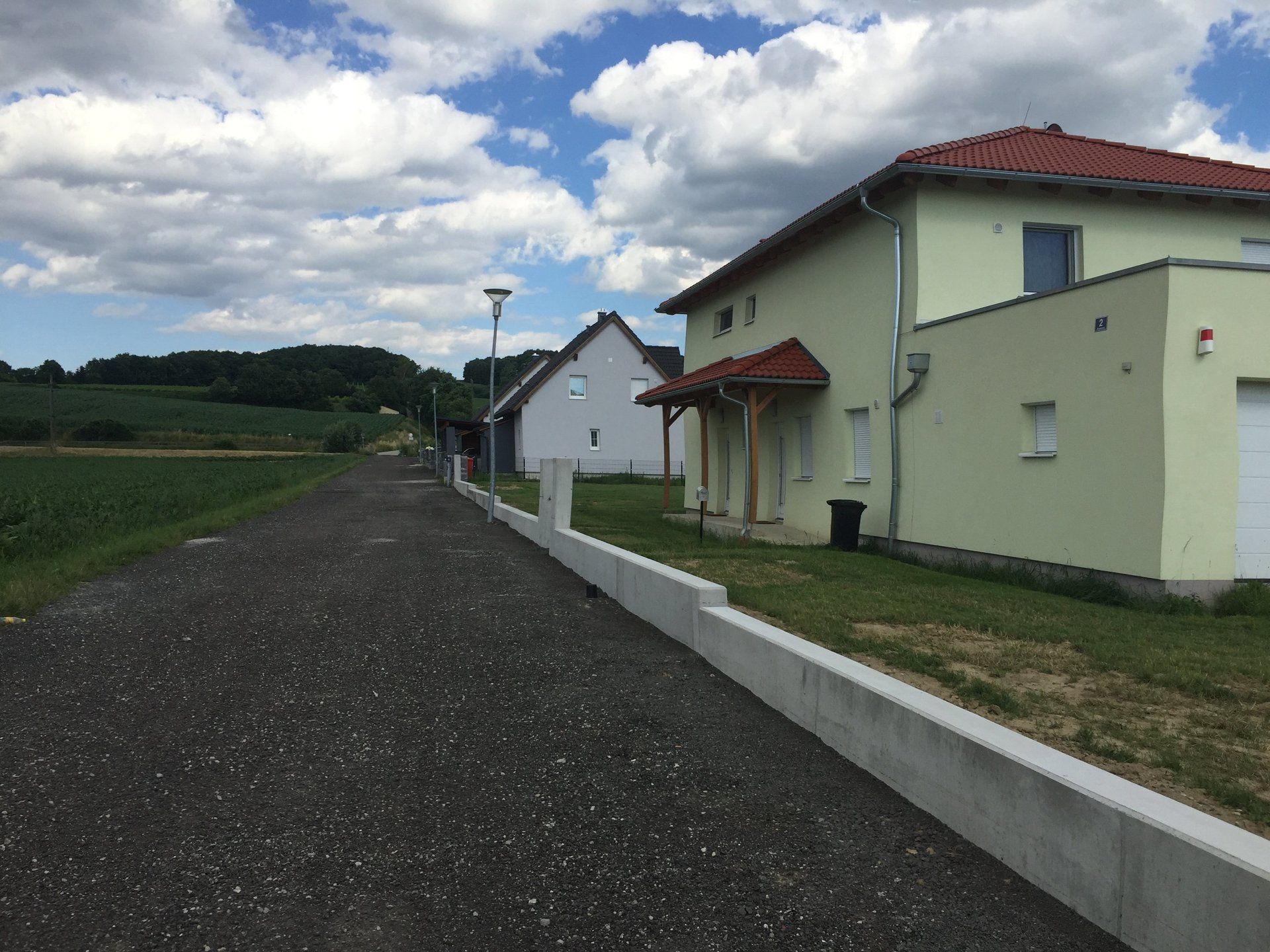 Eine Reihe von Häusern reihen sich an einer unbefestigten Straße aneinander