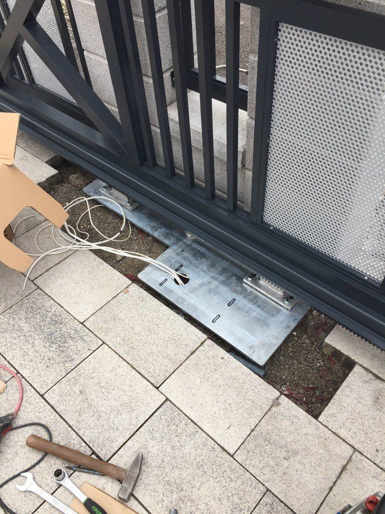 Auf einem gefliesten Boden wird ein Schiebetor montiert.