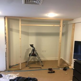 A room with a ladder and a television in it is being remodeled.