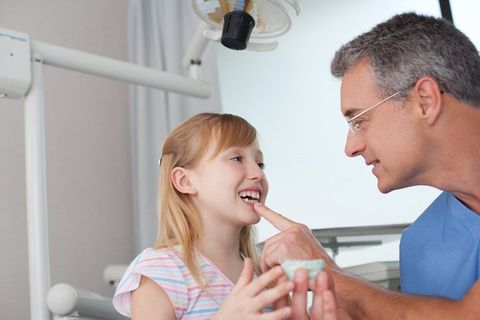 a small girl getting her teeth checked