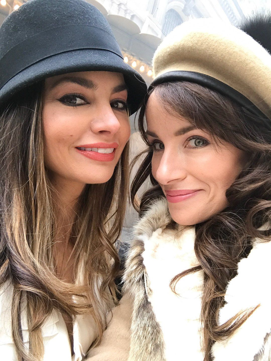 Two women wearing hats are posing for a picture together