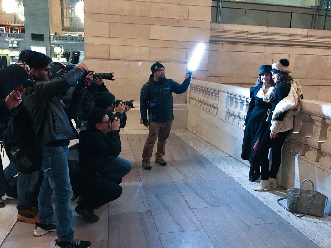 A group of people are posing for a picture with a man holding a light