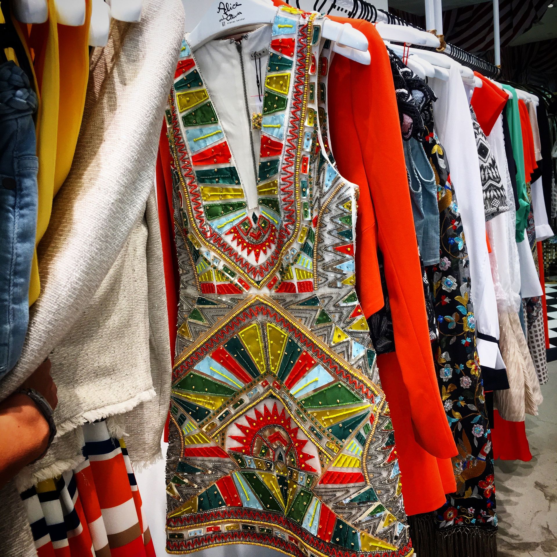 A colorful dress is hanging on a rack in a store
